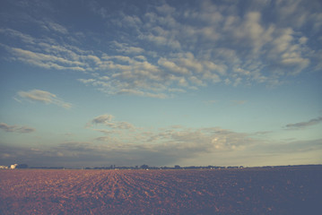 blue sky and cluds over farm land in vintage style