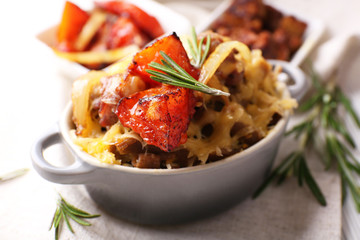 Pasta baked with vegetables and cheese in ceramic pot