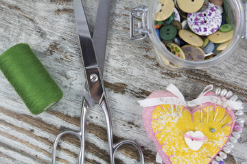 Sewing tools in a wooden background