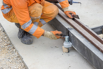 Man applying silicone sealant with putty knife