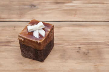 Chocolate muffin with white ribbon on wooden background