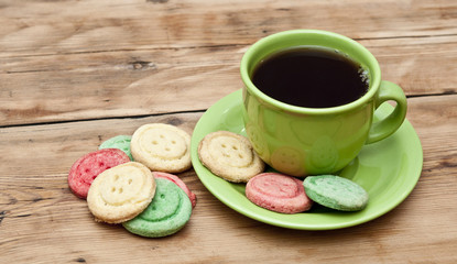 tea cup with colorful cookies, and  brown muffin on table