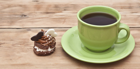 A cupcake on a table with two chocolate hearts