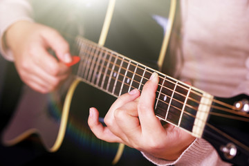 Fototapeta na wymiar Acoustic guitar in female hands, close-up
