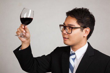 Asian businessman look at  red wine