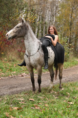 Amazing girl with long hair riding a horse