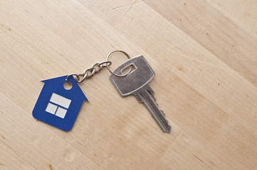 Symbol of the house with silver key on vintage wooden background