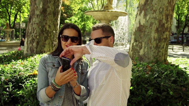 Happy couple doing selfie in the park, steadycam shot