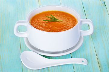 Pumpkin soup in a bowl on a wooden background