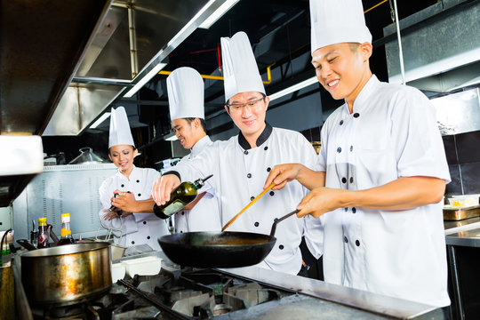 Asian Chefs in restaurant kitchen cooking