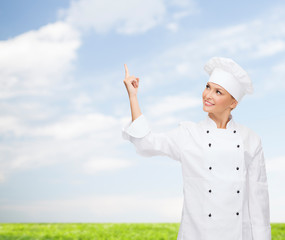 smiling female chef pointing finger to something