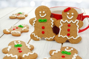 Christmas gingerbread couple with hot chocolate on white wood