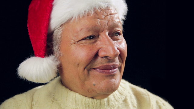 Jolly Old Man With Santa Cap Pointing At Red Gift