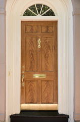 Natural Wood Front Door with White Door Frame and Archway Window