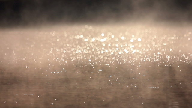 The picturesque water surface with bubbles and steam