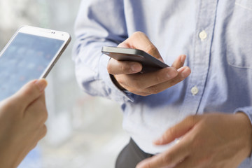 Men and women who are using the mobile phone and face to face