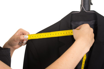 tailor's hand measuring a black suit
