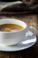 Composition with white cup of coffee on wooden table