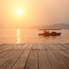 Fototapeta premium plank board with lake in sunset as background