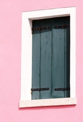 window on a pink wall of the House on the island of Burano in It
