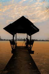 Silhouette waterfront pavilion with photographer