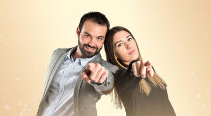 Couple pointing to the front over gloss background