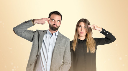 Couple making suicide gesture over gloss background