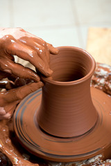 hands of a potter, creating an earthen jar