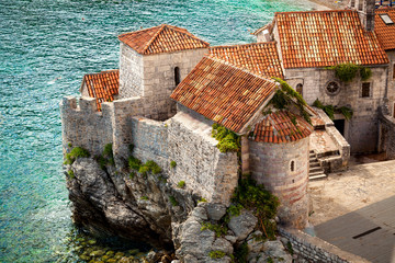 ancient city with red roofs standing on high cliff at seaside