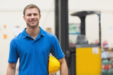 Handsome warehouse worker smiling at camera