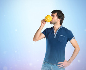Man holding a cup of coffee over blue background