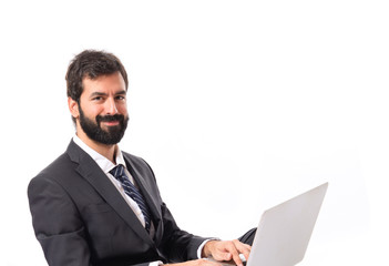 Happy businessman with laptop over isolated white background