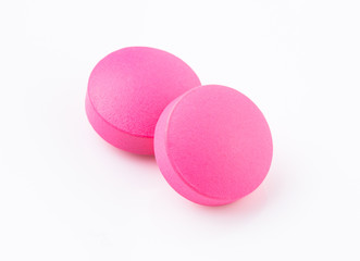 Pink tablet pill on white background