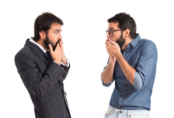 Twin brothers doing surprise gesture over white background