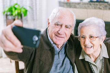 Senior couple showing self portrait photo on smartphone - 73463638