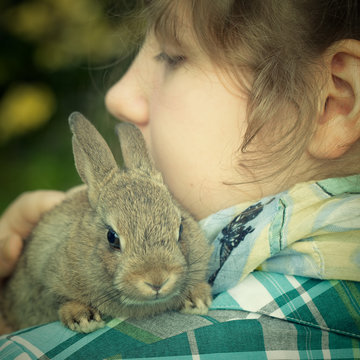 A Teenage Girl Holding A Bunny Rabbit On Her Shoulder