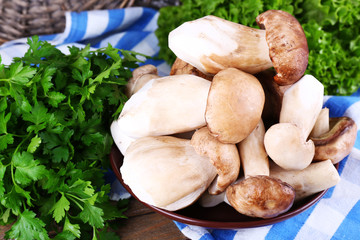 Wild mushrooms on plate with herbs and greens on table