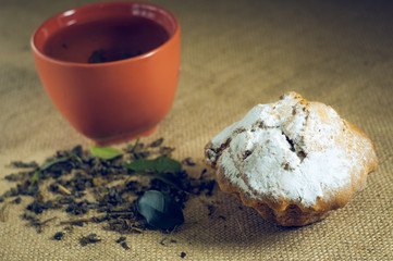 cup of green tea with cake on burlap background