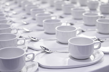 Obraz na płótnie Canvas Stacks of coffee cups with silver teaspoons prepare for meetin