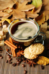 Glass cup of coffee, tasty cookies and autumn leaves