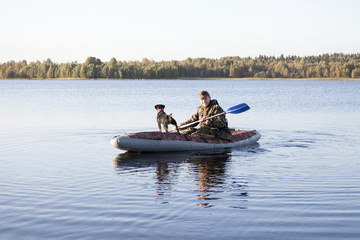 Le chasseur et le chien de chasse flottent sur le lac après la chasse au canard