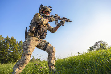 American Soldier aiming his rifle on blue sky background