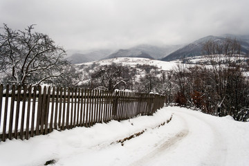 snowy road to village in mountains