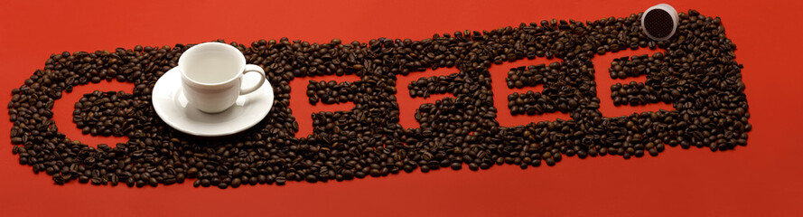 Coffee con chicchi e tazzina su sfondo rosso