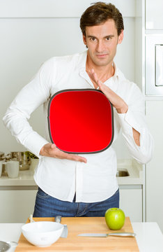 Man in the kitchen with red sign