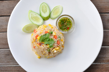Pork fired rice in white plate on wooden table, TOP VIEW.