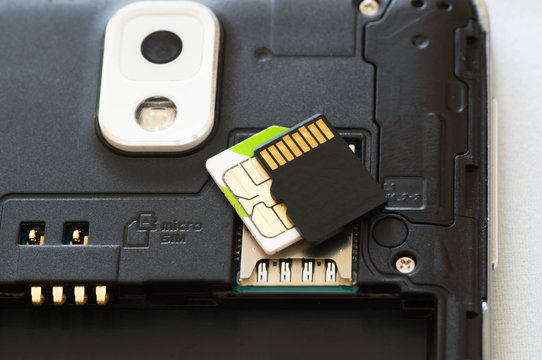 Upper shot of a dismantled smartphone wit SD ans SIM cards