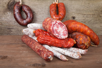 several types of sausages on a wooden background