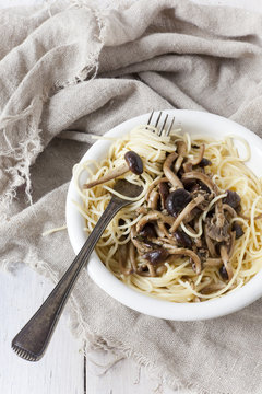 forkful of pasta spaghetti with fresh pioppini mushrooms