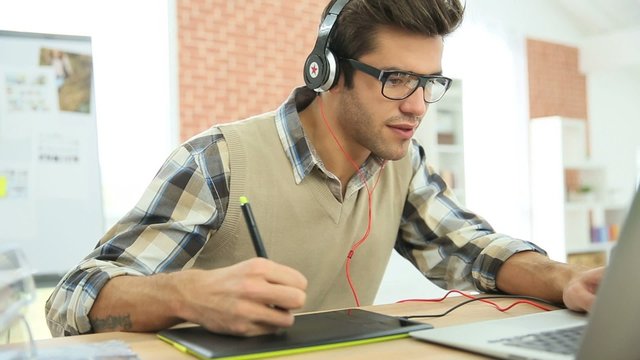 Young man in office using graphic tablet 